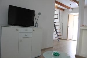 a living room with a tv on top of a dresser at Apartments Platana in Trsteno