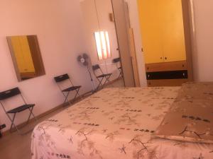 ローマにあるB&P Holiday H.のベッドルーム(ベッド1台、椅子、鏡付)