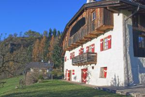 a white building with a balcony on the side of it at Maso Gretel in Tesero