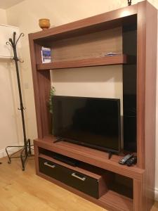 a flat screen tv in a wooden entertainment center at Hameway House in London