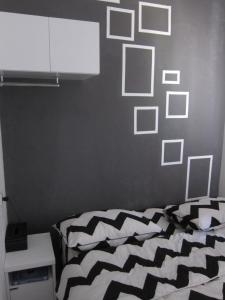 a bedroom with a black and white bed and a wall with pictures at Rumah Baraka in Yogyakarta