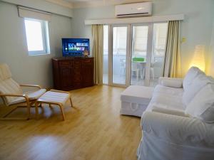 a living room with a couch and a tv at Camilla City apartment in Larnaca