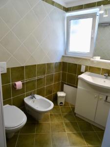 a bathroom with a toilet and a sink and a window at Camilla City apartment in Larnaca