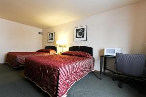 a hotel room with two beds and a desk at Luck Country Inn in Luck