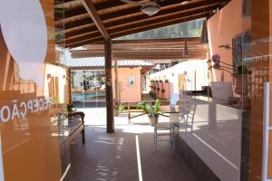 a patio with a table and chairs in a building at Recanto das Carpas in Ilhabela
