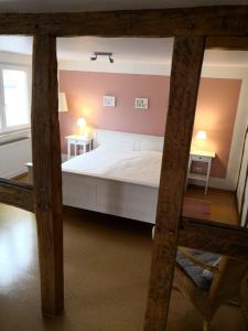 a bedroom with a white bed and two tables at Ferienwohnung-Hallebach in Zell an der Mosel