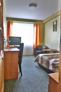 a hotel room with a bed and a desk at Hotel Šiauliai in Šiauliai