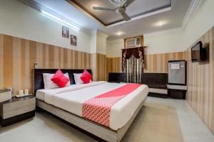 Un dormitorio con una cama grande con almohadas rojas. en Hotel Green Valley, en Guwahati