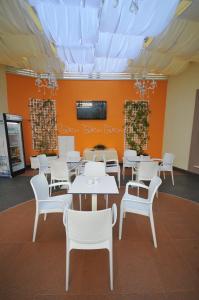 een eetkamer met witte tafels en witte stoelen bij Hotel Vila Kerciku in Tirana