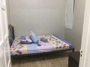 uma pequena cama num pequeno quarto com uma colcha em Taman Rambai Homestay em Malaca