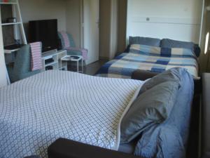 a room with two beds and a desk and a television at Studio Centre Ville Office De Tourisme in Bayonne