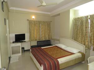 Habitación de hotel con cama y TV en The Corporate Comforts, en Bangalore