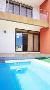 a swimming pool in front of a house at Palmyre Residence 7 & 8 LICENSED BY TOURISM AUTHORITY 10071 in Flic-en-Flac