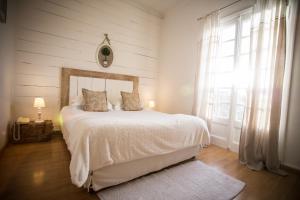 a bedroom with a white bed and a window at La Regalido in Fontvieille