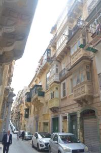 un edificio con coches aparcados frente a él en una calle en Valletta Studio Apartment en La Valeta