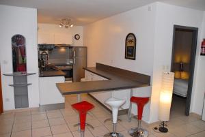 維拉爾－德朗的住宿－Chalet de Montagne Villard de Lans，厨房配有柜台和2张红色凳子