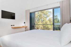 a bedroom with a large white bed and a large window at Maya Maya at Mandoon Estate in West Swan