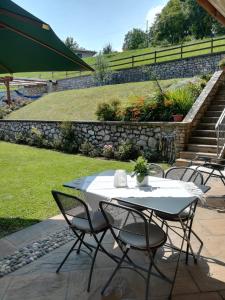 een witte tafel en stoelen in de tuin bij B&B Carmen in San Giovanni Bianco