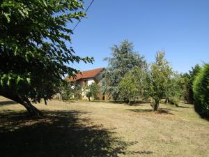 una casa en medio de un patio con árboles en Gîte du Brugayrou, en Gourdon-en-quercy