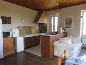 cocina con nevera blanca y sofá blanco en Gîte du Brugayrou, en Gourdon-en-quercy