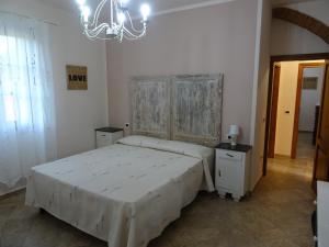 a bedroom with a large white bed and a chandelier at appartamento Podere i Renai in Santa Maria a Monte +49 photos