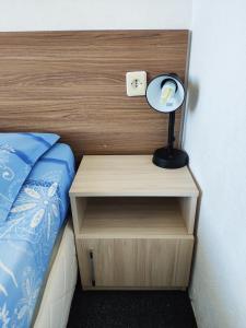 a bed with a night stand with a lamp on it at Villa Maris in Obzor