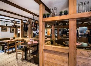 un restaurante con paredes y mesas de madera y un bar en Berggasthaus Piz Calmot en Andermatt
