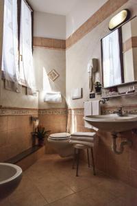 a bathroom with a toilet and a sink and a mirror at Hotel Valentino Centro Storico in Orvieto
