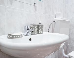 a bathroom sink with two cups on top of it at YES Varna Studios in Varna City +63 photos