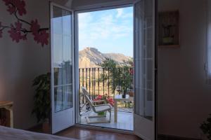 una puerta corredera de cristal con una silla en el balcón en La Casa Viva. Alojamiento responsable y sostenible. en Vélez Blanco