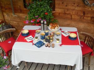 un tavolo con una tovaglia bianca e del cibo sopra di Le Grenier a Saint-Paul-en-Chablais