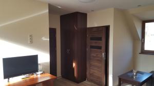 Habitación con TV y puerta de madera. en Sarna Karkonosze en Bukowiec