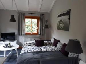Schlafzimmer mit einem Bett, einem Tisch und einem Fenster in der Unterkunft Blockhausperle im Grunen in Oldenburg