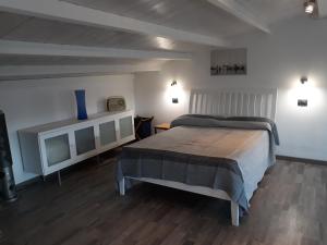 a bedroom with a bed and a shelf with a blue vase at Via Pezza 100 in Ragusa