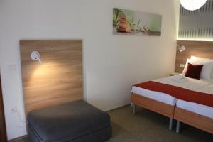 een hotelkamer met een bed en een voetenbankje bij AURA Residence in Rovinj