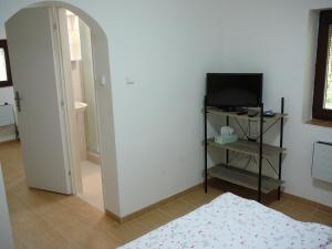 Habitación con dormitorio, TV y puerta. en Chaloupka v Podyjí - Podmolí, en Podmolí