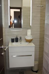 a bathroom with a white sink and a mirror at AURA Residence in Rovinj