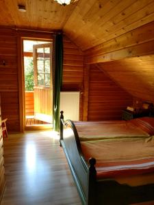 ein Schlafzimmer mit einem Bett in einem Holzhaus in der Unterkunft Holzhaus am Silbersee in Frielendorf
