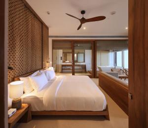 a bedroom with a large bed with a ceiling fan at Riff Hikkaduwa in Hikkaduwa