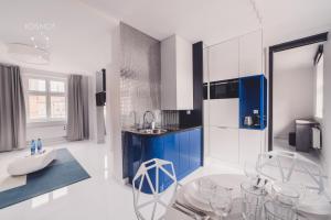kuchnia z niebiesko-białymi szafkami i krzesłami w obiekcie Kosmos 9 - Apartament Orbita w Toruniu