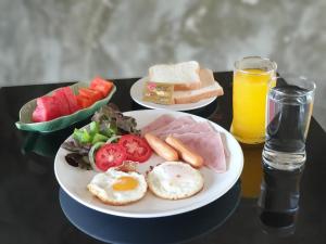 un piatto di prodotti per la colazione e un bicchiere di succo d'arancia di Chiang Klong Riverside Resort a Chiang Khan