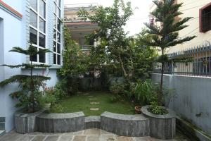 une cour dans un bâtiment avec des arbres et des plantes dans l'établissement Delights Home, à Katmandou