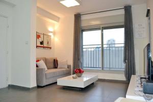 a living room with a couch and a table at Classic 1BR in City Center near Beach by FeelHome in Tel Aviv