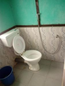 a bathroom with a toilet and a sink at Vamoose Green Valley Village Resort in Pedong