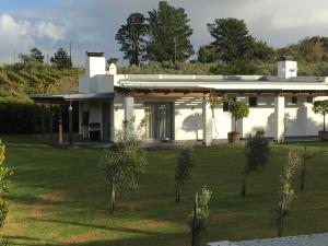 a white house with a green lawn in front of it at Klein Welmoed Luxury Guest House in Stellenbosch