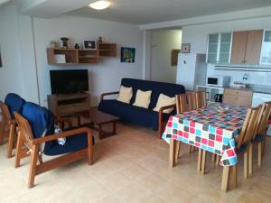 a living room with a blue couch and a table at Brisamarina de Órzola in Órzola
