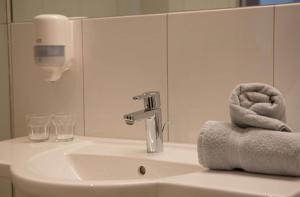 un lavandino in bagno con rubinetto e asciugamani di Hotel Gasthof Lamm a Bregenz