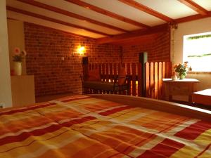 a large bed in a room with a brick wall at Ferienhaus Hagenwinkel in Gernrode - Harz
