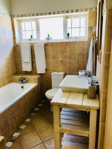 La salle de bains est pourvue d'une baignoire, de toilettes et d'un lavabo. dans l'établissement Cosy Private Cottage, à Port Elizabeth