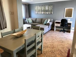uma sala de estar com uma mesa e um sofá em Cosy Private Cottage em Port Elizabeth